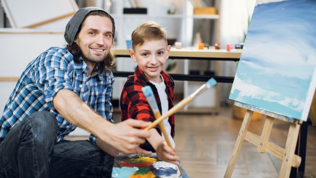 Pedagogisch medewerker schildert samen met een kind