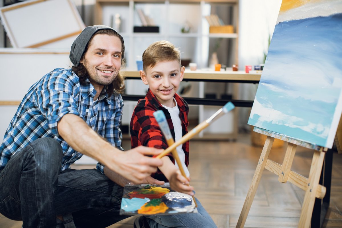 Pedagogisch medewerker schildert samen met een jongetje